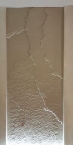 3D Fillit sziklafal bézs színben, szobrászi kialakítással, kézzel -természetes textúrával, egy debreceni modern hálószobában – prémium faldekoráció privát és céges enteriőrökbe Szegeden, Pécsen, Győrben és Budapesten.