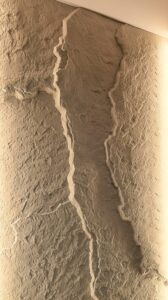 Fillit sziklafal közeli nézet: kézzel formált, rétegzett kőhatású falburkolat meleg élvilágítással. Egyedi 3D textúrájú dekorfal és pala hatású műszikla kivitelezése nappaliba vagy hálószobába Budapesten és országosan.