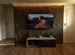 Vulkanikus hatású kézzel formált sziklafal modern nappaliban, beépített médiafallal kivitelezése