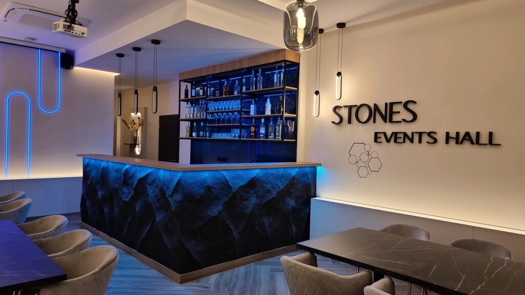 Kézzel formált sziklafal bárpulton – egyedi kőhatású dekorációs fal LED világítással, modern enteriőrben, Stones Events Hall referencia